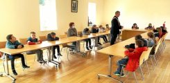 La classe de CE1 assise dans la salle du conseil municipal écoutant Gilles Pagny premier adjoint.